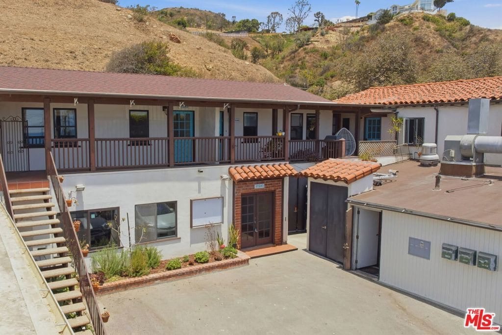 The two-storey building on Pacific Coast Highway, with the hillside rising behind it