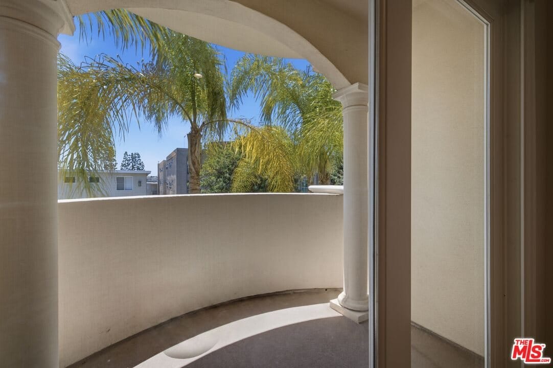 Curved balcony looking out into the palm trees from a Westwood condominium